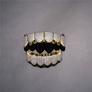 Macro shot of hip hop gold grillz set with sparkling CZ stones and mirror reflections