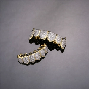 Close-up of gold-plated hip hop grillz set with sparkling white cubic zirconia stones