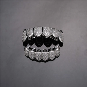 Macro shot of silver hip hop grillz with pavé set cubic zirconia and sharp fang design