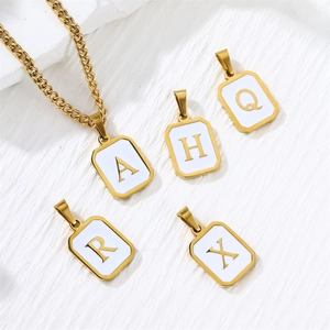 Detail of square gold stainless steel letter pendants with white enamel and chain