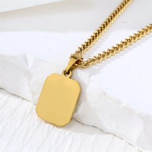 Polished gold square shell necklace pendant close-up view on white marble display