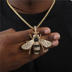 Makroaufnahme von Bienenanhänger mit schwarzen und weißen Zirkonia-Steinen im Hip-Hop-Stil