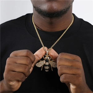Detailaufnahme des großen Gold-Bienenanhängers im Hip-Hop-Stil mit schwarzen und weißen Zirkonia