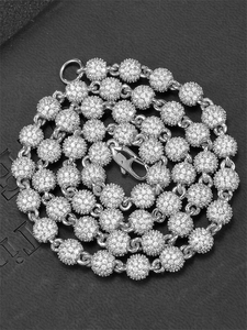 Macro-opname van de zilveren bolletjesketting met pavé gezette zirkoon en karabijnsluiting