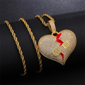 Nahaufnahme der goldenen Hip-Hop-Kette mit zerbrochenem Herz, Zirkonia und Pflaster-Detail