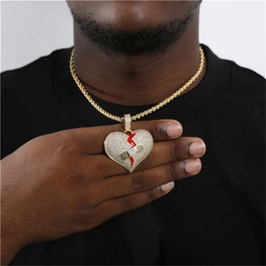 Detail der Hip-Hop-Herzanhänger mit Zirkonia-Pavé und rotem Riss an goldener Kette