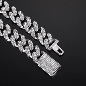 Close-up of iced-out silver Cuban link chain with a diamond-encrusted square clasp