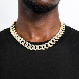 Detailed view of heavy gold-plated iced-out Cuban link chain on male model neck