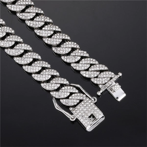 Detailopname van een zilveren Cubaanse schakelketting met diamanten en een stevige sluiting