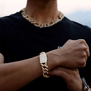 Detailed close-up of a gold-plated Cuban link bracelet and necklace with pavé-set zircons