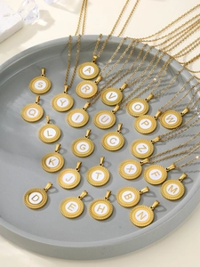 Vue détaillée de 26 pendentifs alphabet dorés avec des bords texturés rayons de soleil