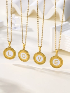 Détail de pendentifs ronds en acier doré avec initiales L O V E et bordure texture corde