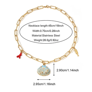Detalle del collar de eslabones de acero dorado con colgantes de coral y concha