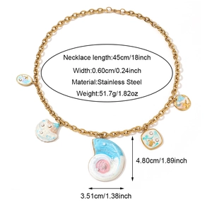 Detalle de collar de cadena de clip dorada con dijes de estrella de mar y caracola marina