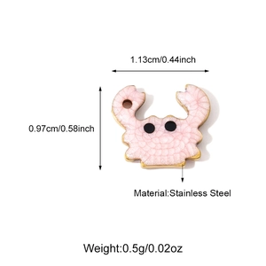Macro view of light pink crab pendant in stainless steel with golden edges and beads