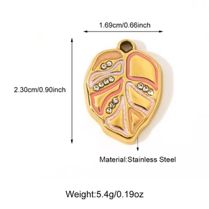 Vue macro d'un pendentif feuille en acier inoxydable avec émail rose et cristaux