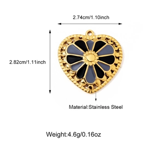 Macro view of stainless steel heart pendant with black enamel floral design and golden border