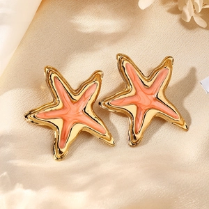 Detalle de pendientes de estrella de mar con baño de oro y esmalte marmoleado sobre seda