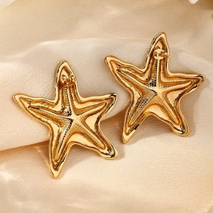 Detalle de la parte trasera del pendiente de estrella de mar dorada sobre tela de seda