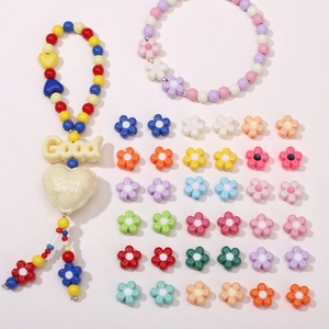 Macro shot of colorful acrylic flower beads and heart charms for DIY jewelry making