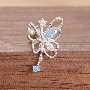 Macro detail of silver stainless steel butterfly cartilage stud with blue zircon