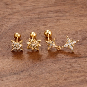 Macro shot of gold star earrings with sparkling cubic zirconia on wood background