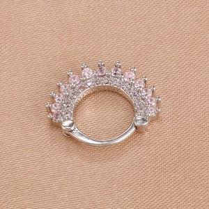 Detailed view of silver crown nose ring with pink zircons on soft silk texture