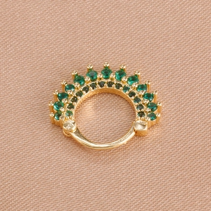 Macro shot of gold hinged earrings with vintage green crystal radiant crown detail