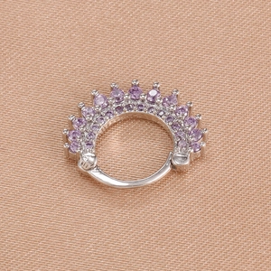 Detail of silver hinged earring set with sparkling purple rhinestones on silk fabric