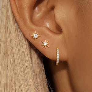 Ensemble de boucles d'oreilles étoiles dorées et créoles en zircon sur l'oreille d'un mannequin