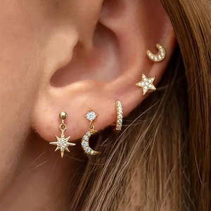 Golden stainless steel celestial earring set with star and moon charms on ear