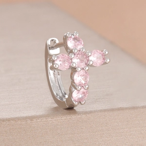 Primer plano de pendiente huggie de plata con colgante de cruz y circonitas rosas