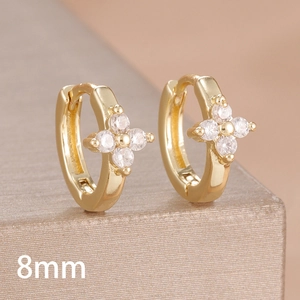 Detailed macro view of 8mm golden hoop earrings featuring sparkling zircon clover patterns