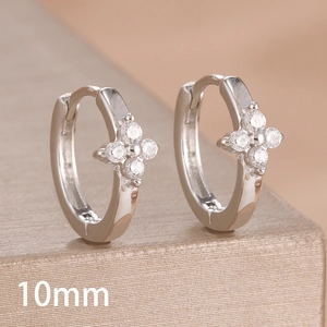 Close-up of 10mm silver huggie earrings with four-leaf clover cubic zirconia inlay