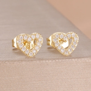Detailansicht der goldenen Herz-Ohrstecker mit funkelnden Zirkonia-Steinen im Pavé-Stil