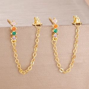 Detailed close-up of golden chain earrings featuring four colorful zircon gemstones