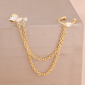 Detail of gold chain earring set with marquise-cut zircons and ear cuff on display