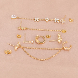 Detail of gold zircon earring set with tassel chains and crystal studs on silk cloth