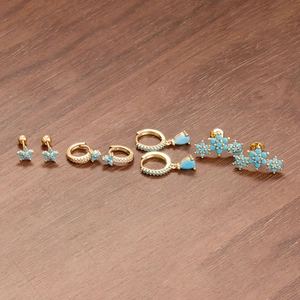 Parure de boucles d'oreilles fleurs dorées avec turquoises et zircons sur bois