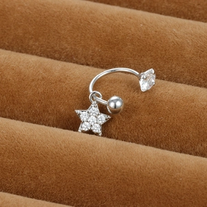 Vue macro d'un piercing de nombril en C avec pendentif étoile en zircon sur velours