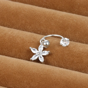 Gros plan sur un piercing de cartilage en forme de C avec pendentif fleur en zircon