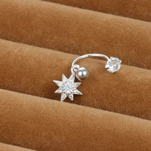 Gros plan d'un piercing nombril en argent S925 avec pendentif étoile à huit branches en zircon
