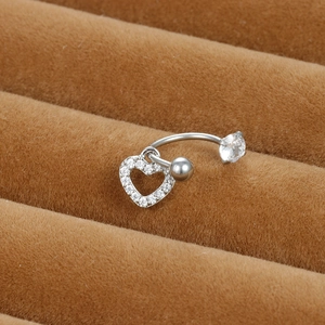 Vue macro d'un piercing de nombril en cœur argenté avec zircons sur présentoir