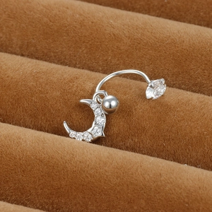 Vue macro du piercing de nombril argenté avec pendentif lune et zircons étincelants