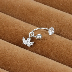 Détail macro du piercing d'oreille incurvé argenté avec pendentif feuille en zircon cubique