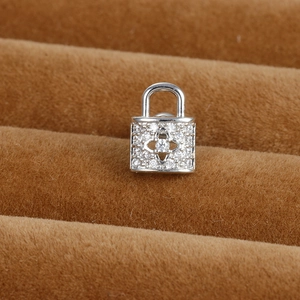 Dettaglio macro dell'orecchino a lucchetto d'argento con zirconi e motivo floreale
