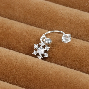 Vue macro d'un piercing de nombril flocon de neige en argent avec pierres en zircon