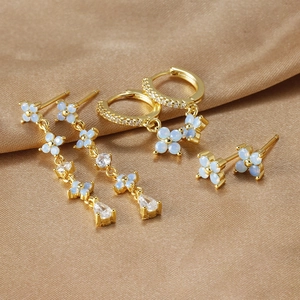 Detail of 18K gold-plated floral earrings with blue petals and sparkling zircon accents