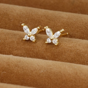 Exquisite goldene Schmetterlingsohrringe mit funkelnden Zirkonen auf einer Schmuckbox
