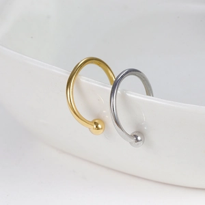 Détail d'anneaux de nez ouverts minimalistes en or et argent sur bord de porcelaine